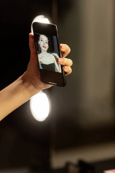 Mulher atraente tomando selfie no estúdio de fotografia — Fotografia de Stock