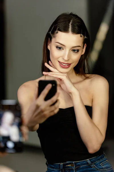 Selective focus of happy woman taking selfie in photo studio — Stock Photo