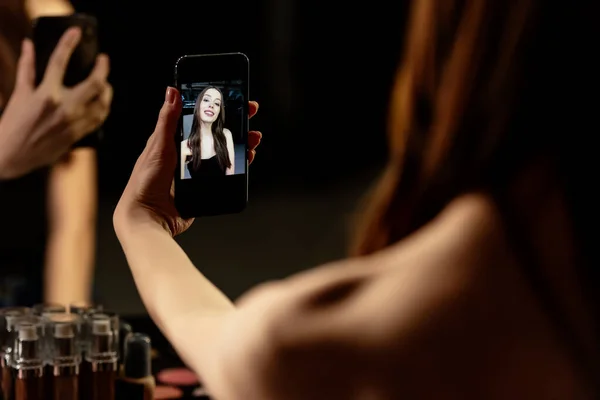 Foyer sélectif de femme gaie prenant selfie en studio photo — Photo de stock