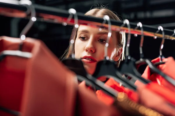 Enfoque selectivo de estilista atractivo mirando ropa de moda - foto de stock