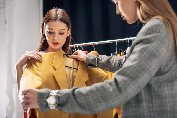 Selektiver Fokus des Stylisten mit gelber Jacke in der Nähe des Modells — Stockfoto