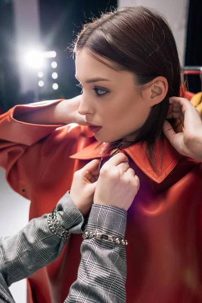 Estilista tocando chaqueta de moda en hermoso modelo - foto de stock