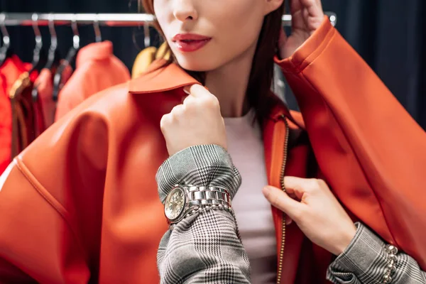 Cropped view of stylist touching jacket on model — Stock Photo