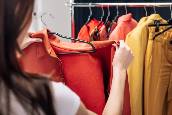 Cropped view of stylist holding hanger with jacket in photo studio — Stock Photo