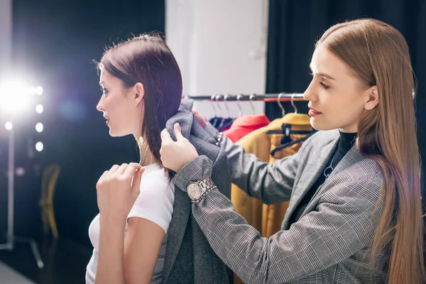 Attractive stylist wearing jacket on young model — Stock Photo