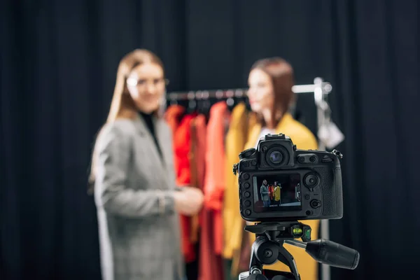 Selective focus of digital camera with happy stylist and model on screen — Stock Photo