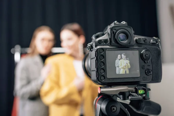 Foco seletivo da câmera digital com estilista e modelo feliz na tela — Fotografia de Stock