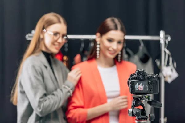 Selective focus of digital camera with happy stylist and cheerful model on screen — Stock Photo
