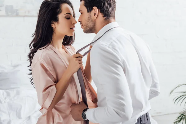 Woman and businessman undressing each other in bedroom — Stock Photo