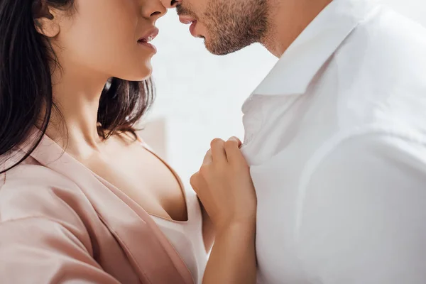 Cropped view of woman unbuttoning male shirt — Stock Photo