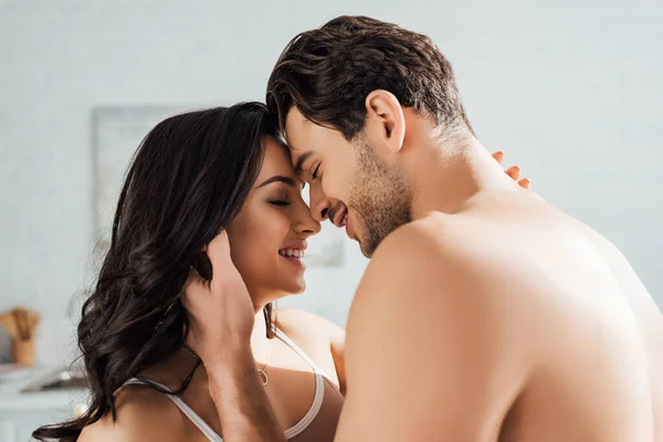 Casal com os olhos fechados sorrindo e abraçando — Fotografia de Stock