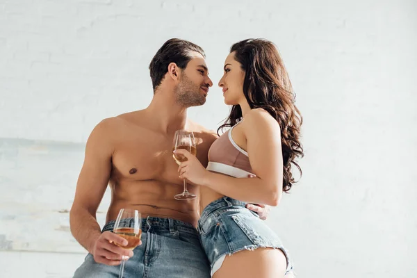 Tiefansicht eines Paares mit Weingläsern, die einander lächelnd anschauen — Stockfoto