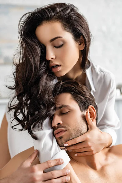 Donna sexy in camicia bianca abbracciare l'uomo con gli occhi chiusi — Foto stock