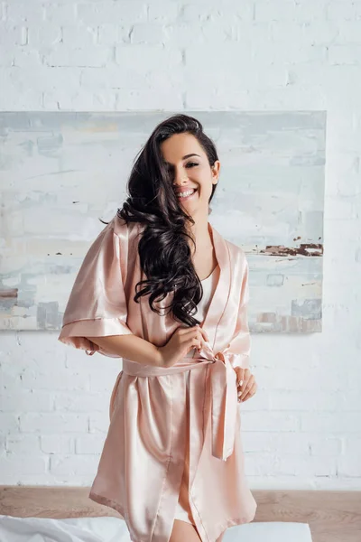 Hermosa mujer sonriendo y mirando a la cámara en el dormitorio - foto de stock