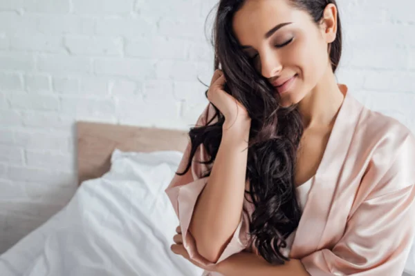 Schöne Frau mit geschlossenen Augen lächelt im Schlafzimmer — Stockfoto