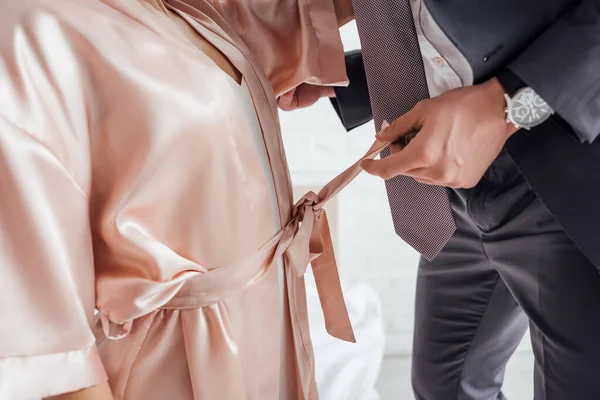 Cropped view of businessman undressing woman in bedroom — Stock Photo