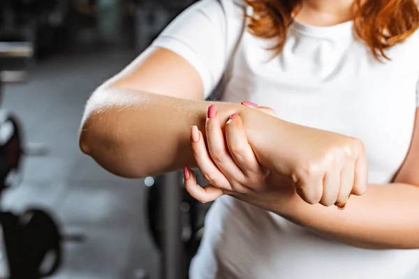 Partial view of overweight girl checking pulse with hand — Stock Photo