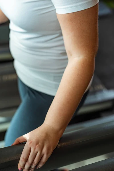 Cropped view of overweight girl exercising in sports center — Stock Photo