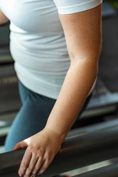 Vista recortada de la chica con sobrepeso haciendo ejercicio en el centro deportivo - foto de stock