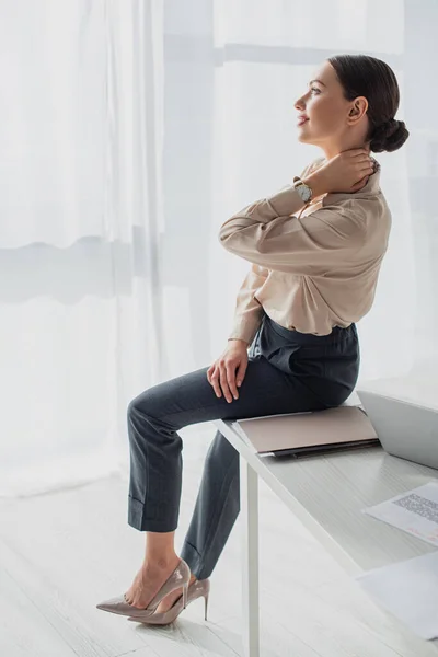 Femme d'affaires fatiguée heureuse étirant le cou dans le bureau moderne — Photo de stock