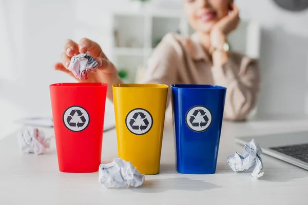 Cropped view of businesswoman throwing crumpled papers into recycling buckets  in office — Stock Photo