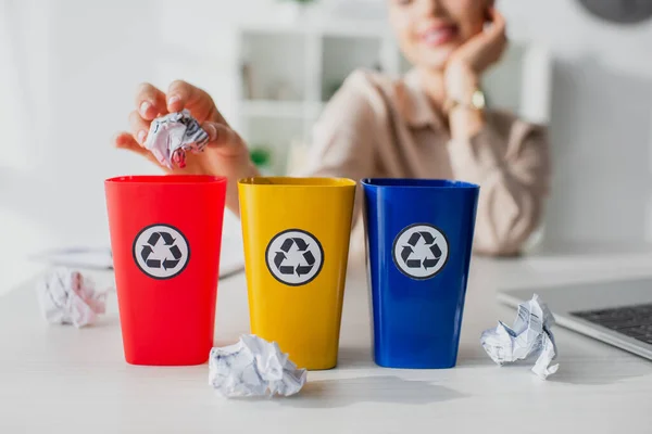 Abgeschnittene Ansicht einer Geschäftsfrau, die im Büro zerknüllte Papiere in Recycling-Eimer wirft — Stockfoto