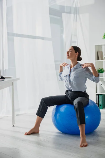 Beautiful happy businesswoman exercising on fitness balls in office — Stock Photo
