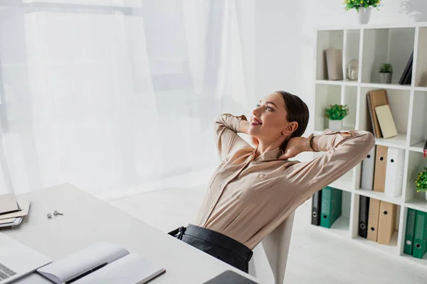 Giovane donna d'affari sorridente procrastinare sul posto di lavoro in ufficio — Foto stock