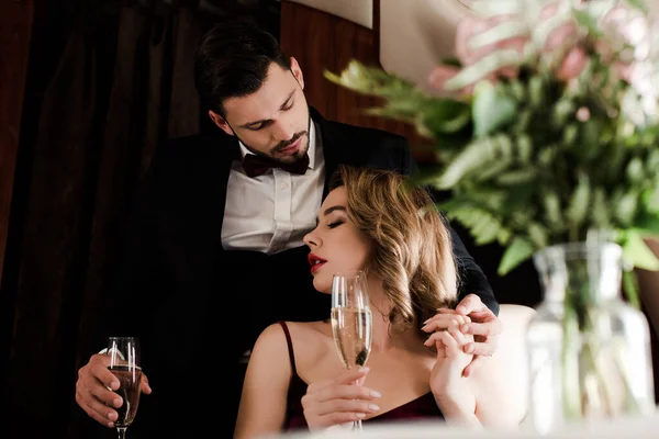 Selective focus of elegant couple holding champagne glasses in plane — Stock Photo