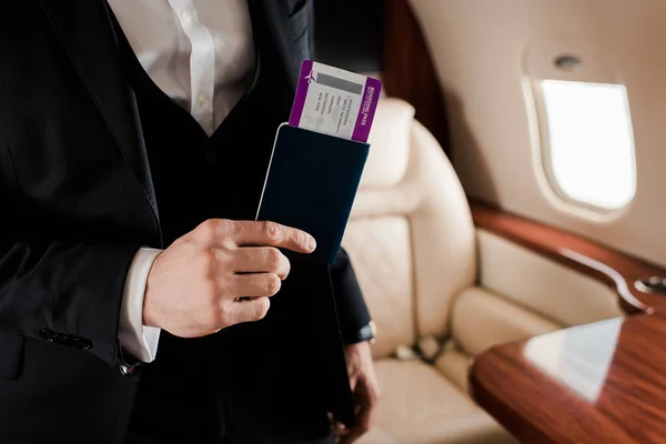 Visão parcial do homem elegante que possui passaporte e passagens aéreas no avião — Fotografia de Stock