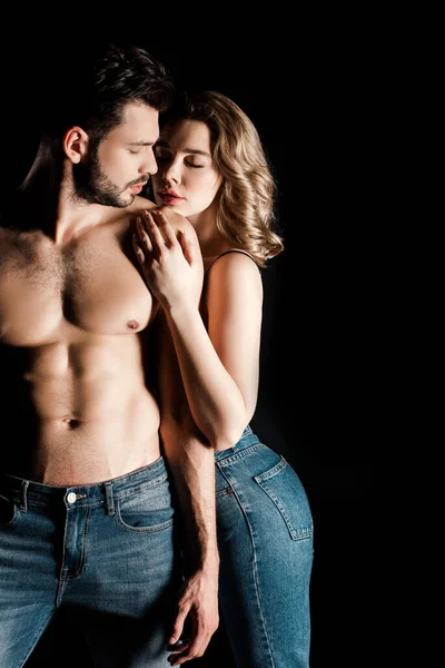 Ragazza sensuale che abbraccia senza maglietta, fidanzato muscoloso isolato su nero — Foto stock