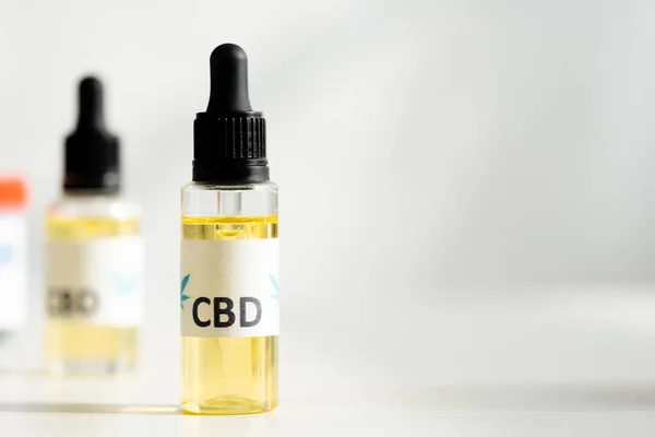 Selective focus of bottle with oil and cbd lettering on table — Stock Photo