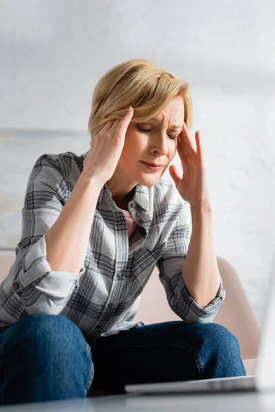 Mature woman with closed eyes suffering from migraine — Stock Photo