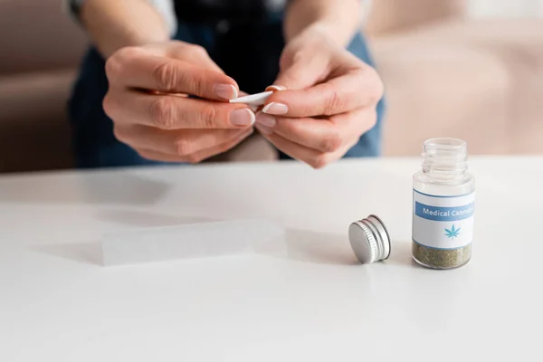 Abgeschnittene Ansicht einer reifen Frau, die Papier in der Nähe einer Flasche mit medizinischem Cannabis-Schriftzug hält — Stockfoto