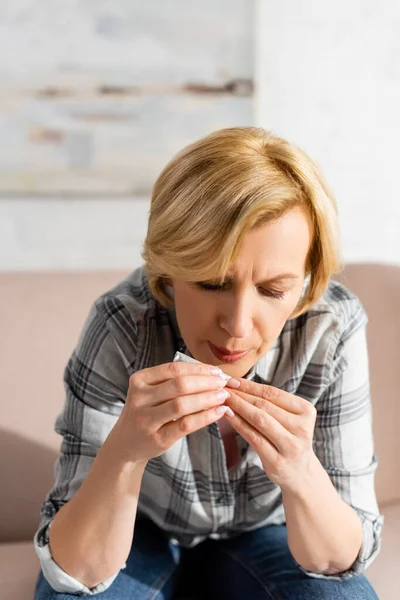Mature woman blowing on joint with legal marijuana at home — Stock Photo