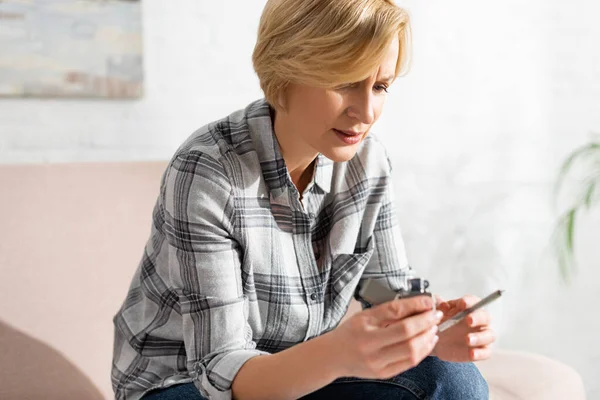 Selective focus of mature woman holding joint with weed and lighter — Stock Photo