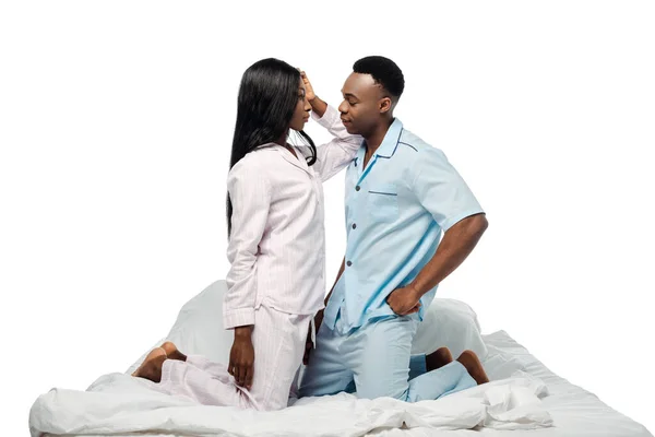 Couple afro-américain se regardant dans le lit en pyjama isolé sur blanc — Photo de stock