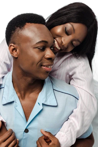Feliz africano americano pareja abrazándose en pijama aislado en blanco - foto de stock