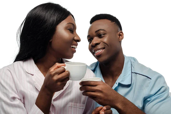 Feliz africano americano pareja bebiendo café en pijama aislado en blanco - foto de stock