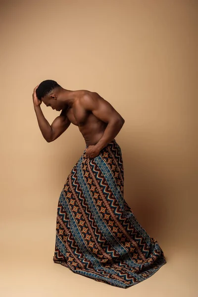 Sexy nu tribal afro homme couvert de couverture posant sur beige — Photo de stock