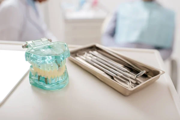 Selective focus of dental instruments near teeth model in clinic — Stock Photo