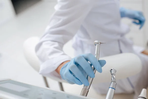 Cropped view of dentist taking stainless dental instrument — Stock Photo