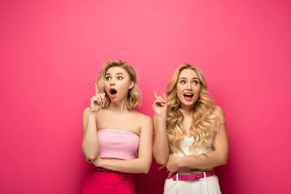 Aufgeregt blonde Mädchen mit Idee auf rosa Hintergrund — Stockfoto