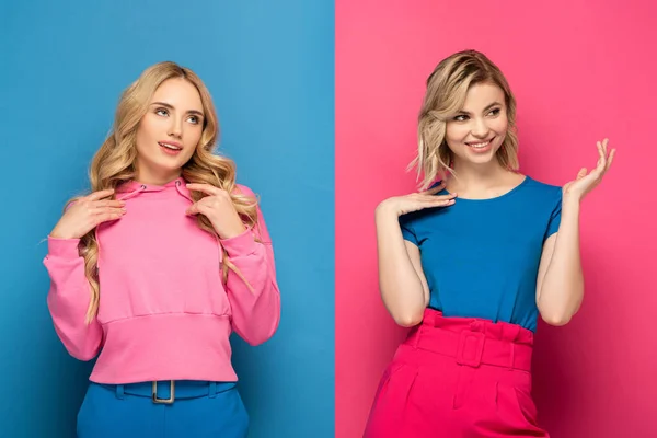 Sonrientes hermanas rubias mirando hacia otro lado sobre fondo rosa y azul - foto de stock