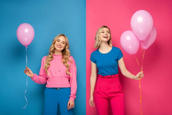 Alegres chicas rubias sosteniendo globos sobre fondo azul y rosa - foto de stock