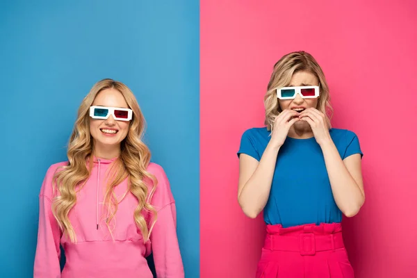 Smiling and scared blonde sisters in 3d glasses on blue and pink background — Stock Photo
