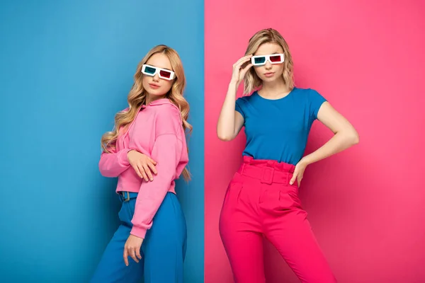 Hermosas chicas rubias en gafas 3D sobre fondo azul y rosa - foto de stock