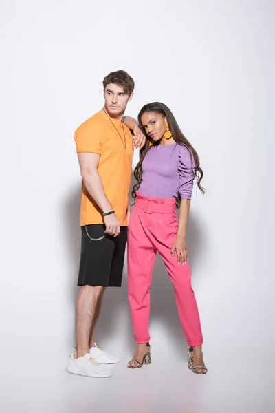 Full length view of stylish african american girl leaning on shoulder of handsome boyfriend on white background — Stock Photo