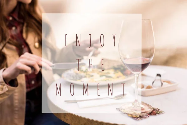 Partial view of woman eating with glass of wine in cafe, enjoy the moment illustration — Stock Photo