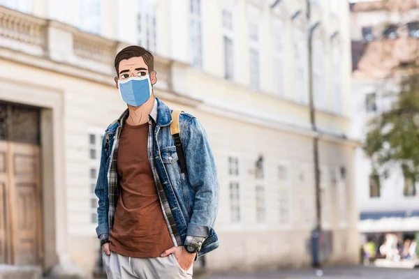 Bonito homem com rosto ilustrado em máscara médica e mãos em bolsos na rua — Fotografia de Stock